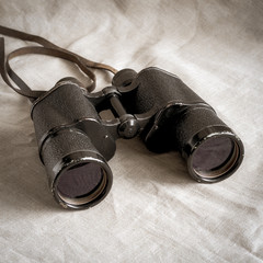 Old big binoculars close-up. In muted tones, sepia.