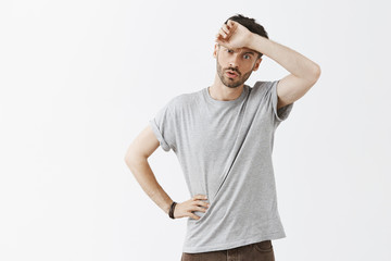 Man feeling relieved escaping from dangerous situation whiping sweat from forehead breathing out...