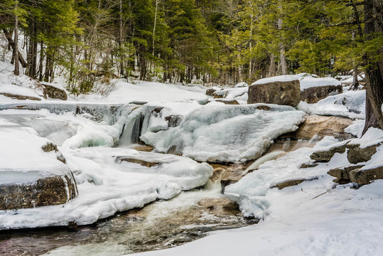 Frozen water fall rapids in winter time with snow
