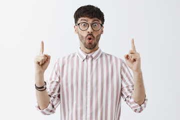 Excited enthusiastic good-looking mature guy with beard folding lips and staring with excitement...