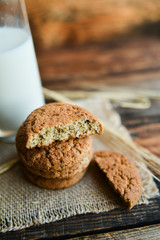 fresh homemade oatmeal cookies on wooden background with spikes of oats
