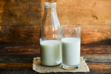 glass of milk, cow on natural wooden background in rustic style, rural style, concept of natural products and farming