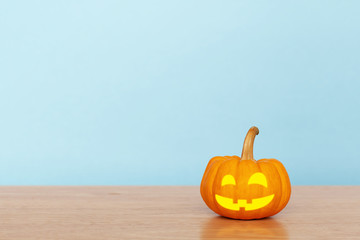 Pumpkin on wood table with blue background. Halloween and decoration concept. Front view and copy space