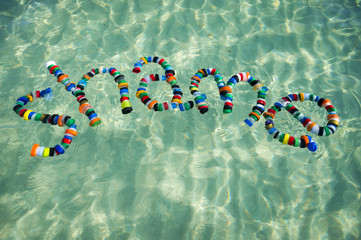 Colorful bottle caps spell out the word 'shame' on the sea. Take action on pollution - reduce,...