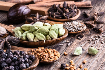 Different types of whole Indian spices in wooden background close-up.