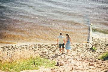 Summer, love. Attractive couple walking on the beach