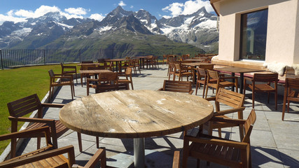 Empty Restaurant Tables and Chairs On Top Deck in Mountains