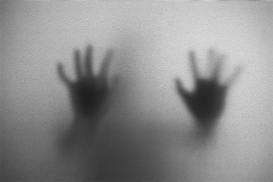 Shadow of man on the white frosted glass