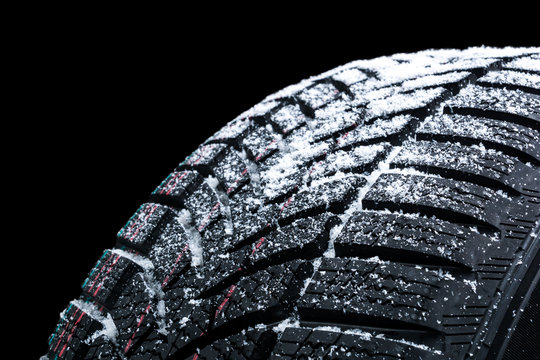 Winter car tires with snow wheel profile structure on black background - Close up