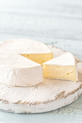 Camembert with capers on the wooden board