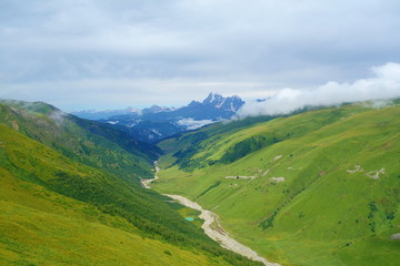 Fototapeta na wymiar View from Chkhunderi mountain pass to valley and Khaldechala river in the summer in Svaneti region, Georgia