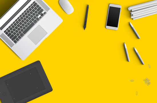 Minimal work space concept: smart phone, pen, pencils, tablet, laptop, composition on yellow background. Flat lay, top view. Copy space