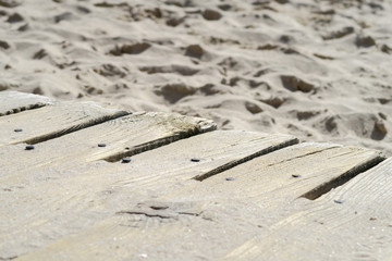 Sandy wood planks on beach fixated with rusty nails | Sidewalk for tourists on seaside
