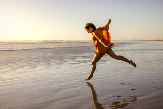 Woman having fun running on the sea shore