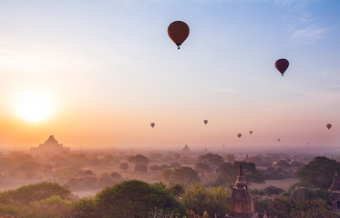  plain of Bagan Myanmar (Burma) is filled with the Golden light of the sun with the silhouettes of balloons