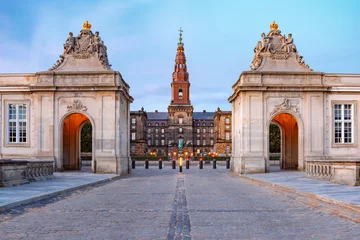 Fotobehang The main entrance to Christiansborg with the two Rococo pavilions on each side of the Marble Bridge during morning blue hour, Copenhagen, capital of Denmark © Kavalenkava