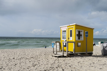 Cute bright yellow wooden cabin at beachside | Tiny house built on sand at seaside | Sylt, Germany 