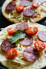 Mini Pizza With Cherry Tomatoes And Salami Sausages On A Wooden Background Natural Rustic, A Pizza Cutter And Ingridienty.