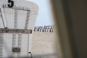 Fototapeta na wymiar Several empty white beach chairs lined up at the beach | Selective focus 