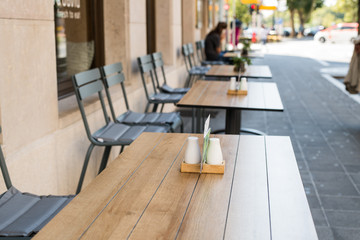 Typical summer outdoor cafe. Tables and chairs summer cafe, restaurant on streets of city in anticipation of visitors. Interior cafe with outdoor area.