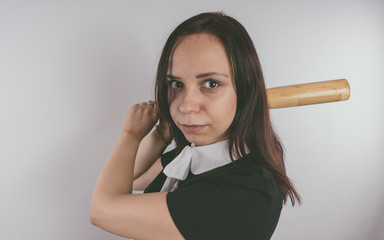 A girl in a black dress with a baseball bat in her hands. Concept: the bully at school