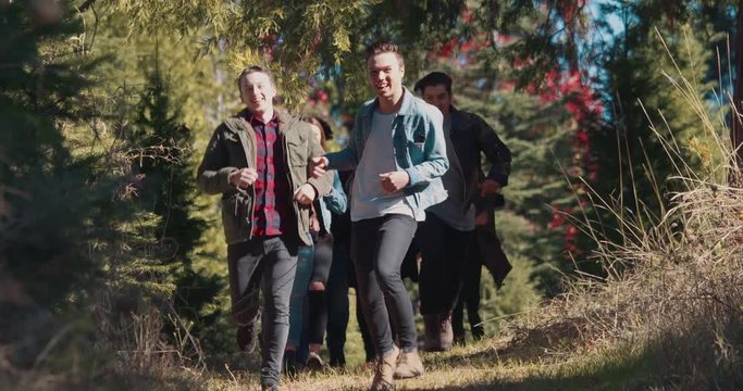 Group of Millennials  Running together out in a natural setting. 4k, slow motion stock video clip. All models from diverse ethnic backgrounds.