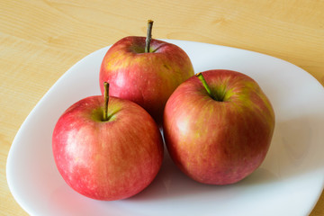 Apple fruits on the plate on the table.