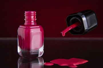 Brush detail of a nail varnish with drop /  Close up of the brush of a nail polish with poured nail polish and glass flask