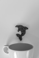 Dolphin made of coffee jumping from cup