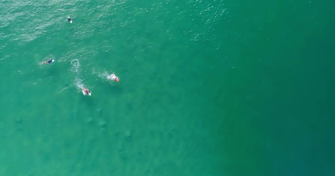 Aerial Top down view of surfers floating on ocean waves