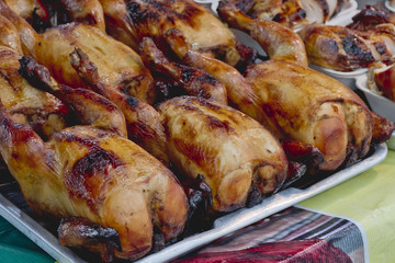 Many Roasted chickens served on stainless tray.