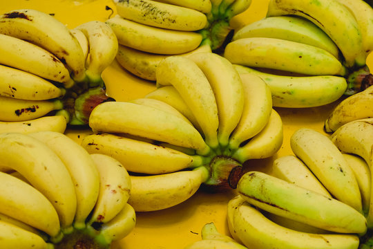 Bright yellow bunch of appetizing ripe bananas background texture