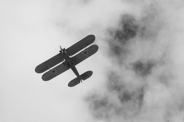 Black and white photo of biplane on airshow in Krakow, Poland. Historical war plane, with stars on...