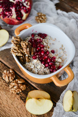Tasty homemade Breakfast: oatmeal with pomegranate and nuts on natural wooden background rustic. The concept of a healthy diet, a high-carbon Breakfast.