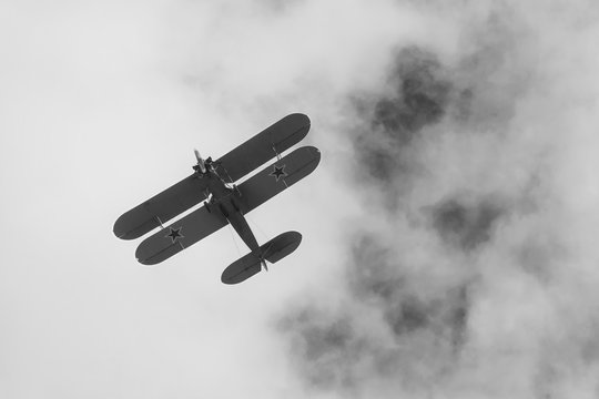 Black and white photo of biplane on airshow in Krakow, Poland. Historical war plane, with stars on wings, monochrome design.