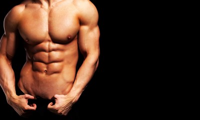 Close up of perfect male body isolated on black background with