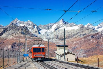 red tram or train on rail to Matterhorn, popular Alps peak at Zermatt Switzerland