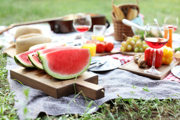 Decke mit Lebensmitteln, die für ein Sommerpicknick im Freien zubereitet werden