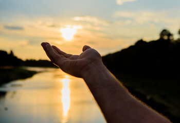 Male hand pointing at sun in blue sky at evening time admire landscape. Capture moment to admire...