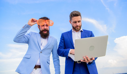 Businessman with laptop serious while business partner ridiculous glasses looks funny....