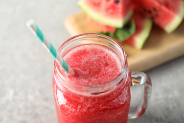 Tasty summer watermelon drink in mason jar on table, closeup