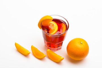 Glass with orange drink near juicy orange fruit on white background, close up. Cocktail or beverage with orange juice. Cocktail concept. Drink or beverage with orange