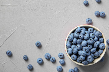 Flat lay composition with juicy and fresh blueberries on color table. Space for text