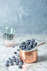 Cookware with juicy and fresh blueberries against blurred background