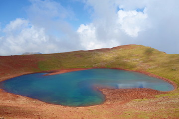 Colorful and breathtaking view at the top of Azhdahak volcano with a turquoise lake hidden inside in Geghama mountains, Armenia