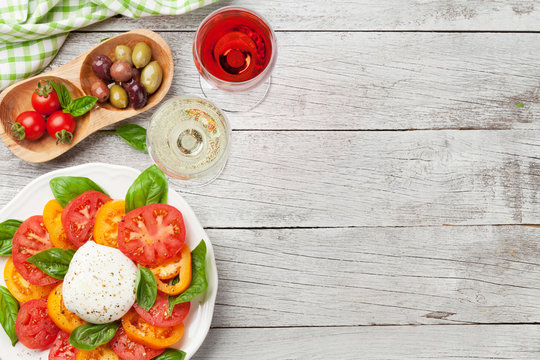 Caprese salad with tomatoes, basil and mozzarella with wine