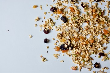 Tasty oat granola with raisins, coconut, seeds on the white background