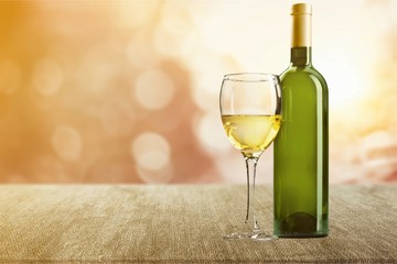 Glass and bottle of white wine on grunge background