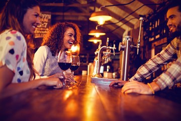 Young women interacting with bartender at counter