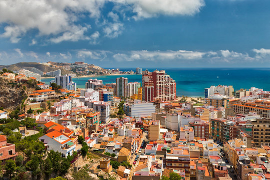 Beautiful above view of the vacation area of Cullera, Spain, showing the city and the coastline with a bright blue sky and white clouds